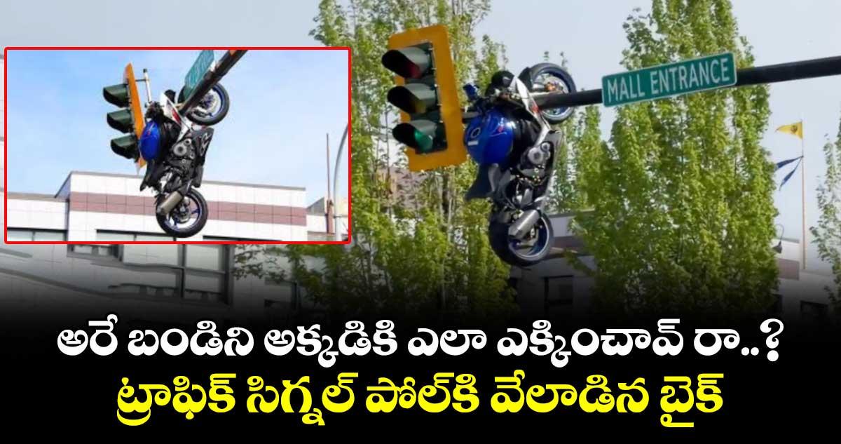 అరే బండిని అక్కడికి ఎలా ఎక్కించావ్ రా..? ట్రాఫిక్ సిగ్నల్ పోల్కి వేలాడిన బైక్